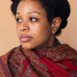 Photo portrait of Allison Janae Hamilton wearing a patterned red scarf