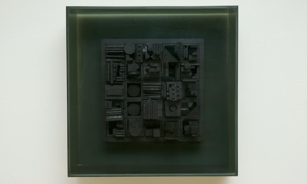 A square, black painted piece of wood with various shapes, and plexiglass cover