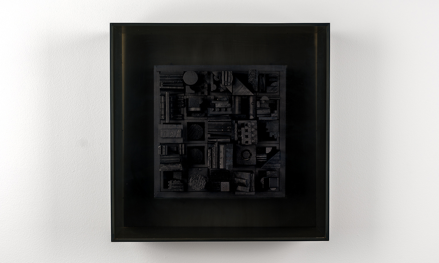 square, black painted piece of wood with various shapes, and plexiglass cover