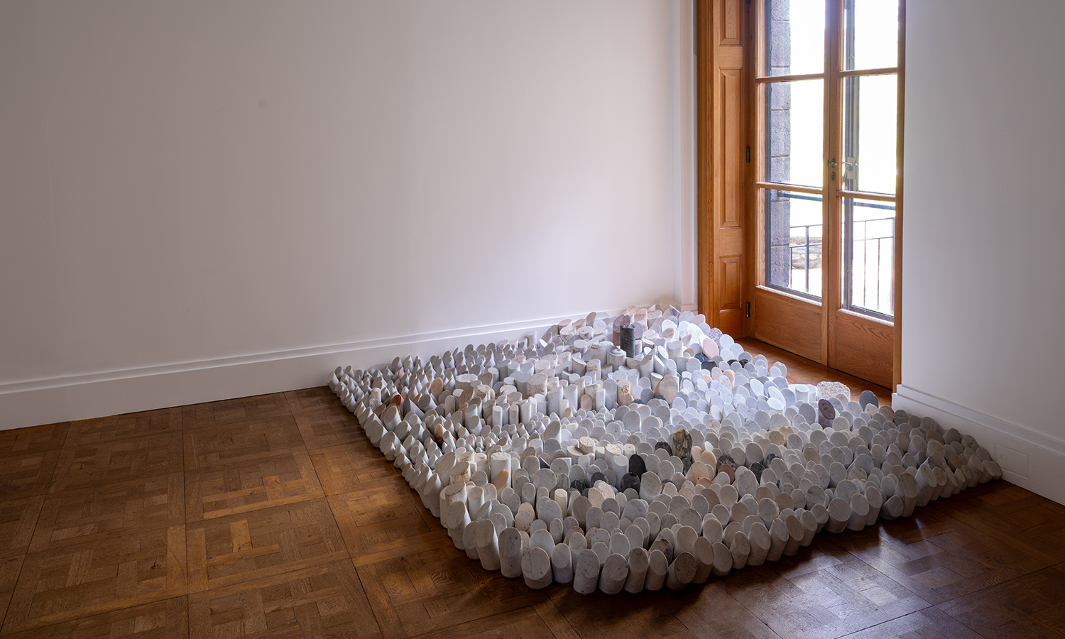 1,200 cylindrical pieces of marble and travertine of various heights sit close to the floor.