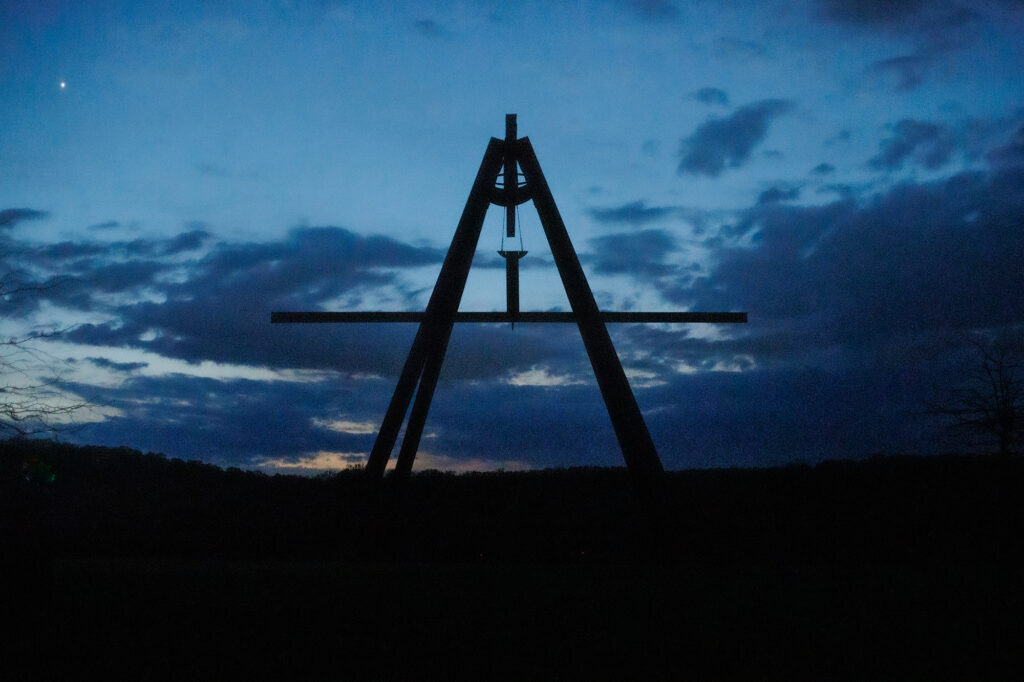 Against the dark dusky blue sky, the steel sculpture Pyramidian appears black.