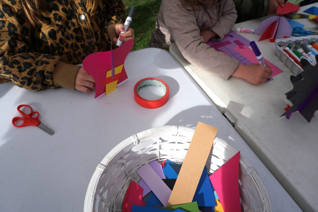 Participants' hands working with paper materials at the table.